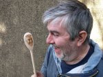 Man looks a t his own face on a spoon